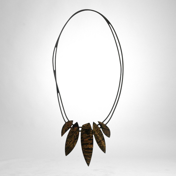 Style and Grace JUNO black necklace featuring a multi-leaf pendant design with textured gold and black detailing.