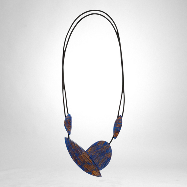 Style and Grace JUNO blue necklace featuring layered leaf-shaped wooden pendants with textured brown detailing
