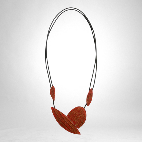Style and Grace JUNO red statement necklace featuring textured leaf-shaped pendants on a double black cord.