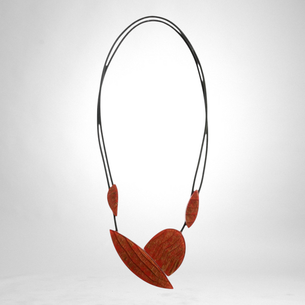 Style and Grace JUNO red statement necklace featuring textured leaf-shaped pendants on a double black cord.